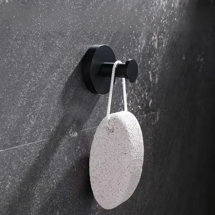 Un crochet ventouse noir sur un mur gris dans une salle de bain