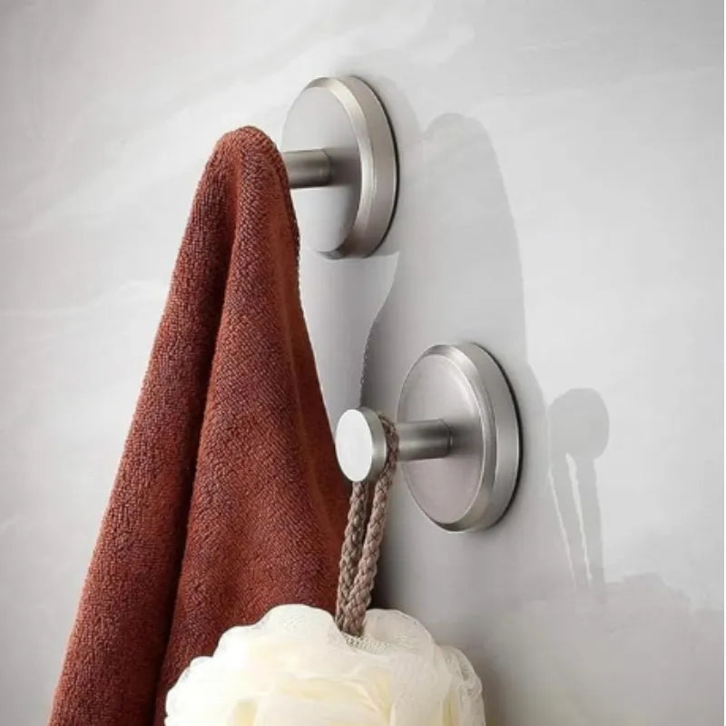Deux crochets ventouse gris permettent d'accrocher une serviette de bain et un accessoire de douche