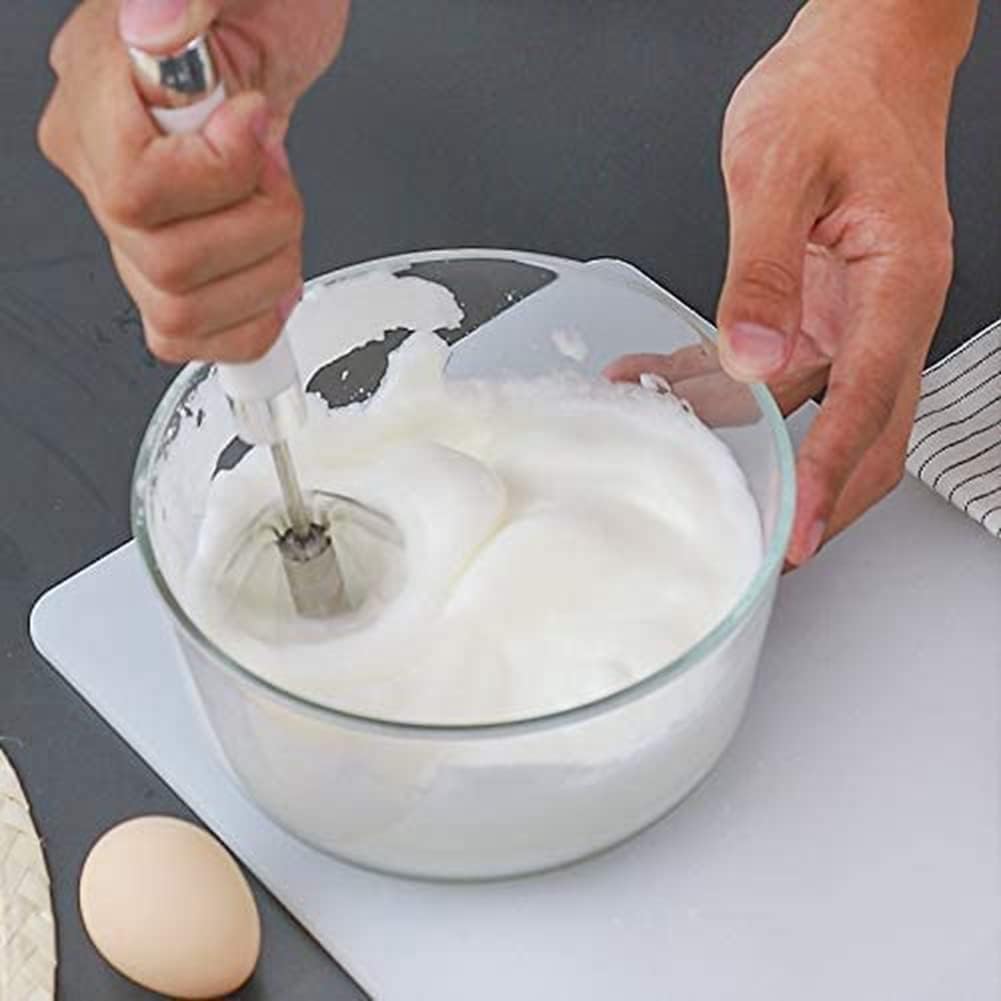 Des mains activent un fouet rotatif en inox dans un petit saladier pour monter des œufs en neige