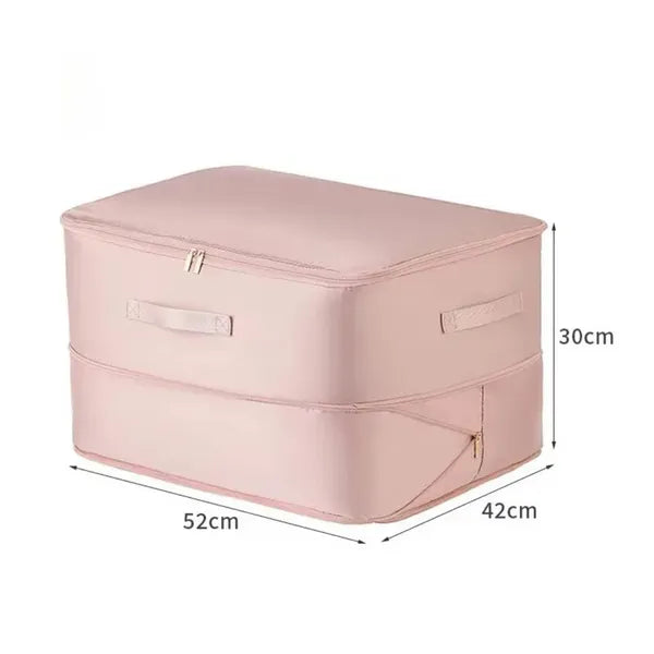 Un sac de rangement par compression couleur rose est exposé sur un fond blanc avec ses dimensions écrites