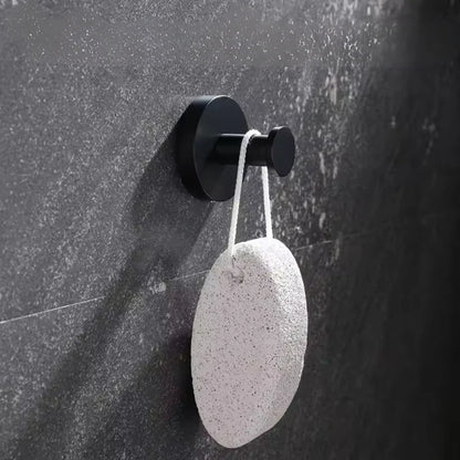 Un crochet ventouse noir sur un mur gris dans une salle de bain