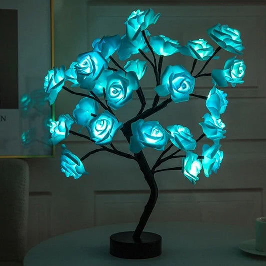 Une magnifique lampe aux leds avec des fleurs de rose de couleur bleue est allumée dans le noir