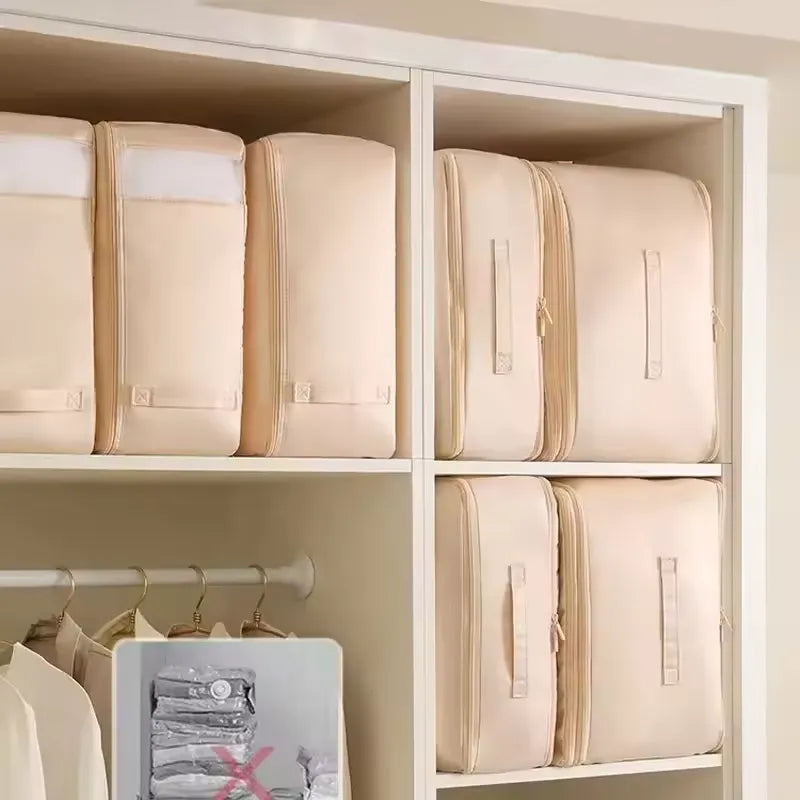 Plusieurs sacs de rangement avec système de compression sont rangs proprement sans une armoire blanche