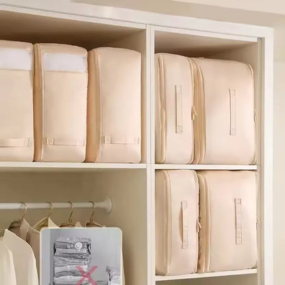 Plusieurs sacs de rangement avec système de compression sont rangs proprement sans une armoire blanche